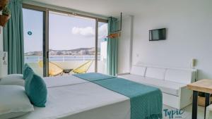a bedroom with two beds and a view of the ocean at Typic Marina Playa - Adults Only in San Antonio Bay