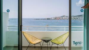 uma varanda com 2 cadeiras e vista para o oceano em Typic Marina Playa - Adults Only em Baía de San Antonio