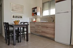 a kitchen with a table and a refrigerator at Keshet Eilon - Suites and Villas in Elon