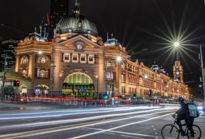 - un homme à vélo dans une rue en face d'un bâtiment dans l'établissement Homestay - Yarra River Boulevard, à Melbourne