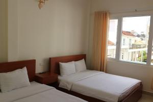 Duas camas num quarto com uma janela em Mây Đà Lạt Home em Da Lat