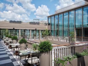 a balcony with tables and chairs and a building at Rosewood Vienna in Vienna
