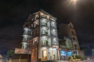 a tall building with lights on it at night at Quốc Khánh Condotel in Da Lat
