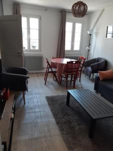 uma sala de estar com mesa e cadeiras em Bienvenue à Strasbourg - Krutenau em Estrasburgo