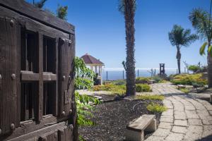 a wooden door and a walkway with palm trees at Eco Finca Vista Bonita in San Miguel de Abona