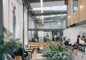 a restaurant with people sitting at tables and plants at Homestay - Yarra River Boulevard in Melbourne