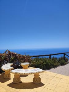 two stone tables sitting on a patio overlooking the ocean at Cortijo Mirador de Almuñecar in Taramay
