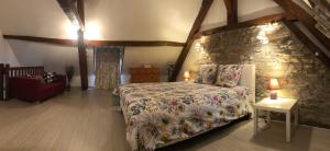 - une chambre avec un lit et un mur en pierre dans l'établissement Gîte des Bruyères, à Graçay