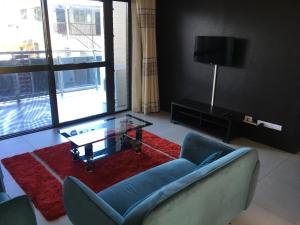 a living room with a couch and a glass coffee table at Bhan Towers Apartment in Suva