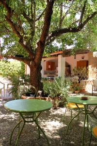 dwa stoły i krzesła przed drzewem w obiekcie Sweet Home & Apartments w mieście Fontane Bianche