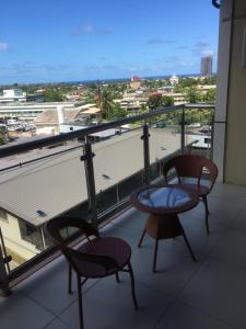 two chairs and a table on a balcony with a view at Bhan Towers Apartment in Suva