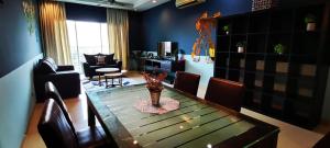 a dining room with a table and chairs and a living room at KLCC Amazing Robots Homestay 4Bedrooms (13pax) in Kuala Lumpur