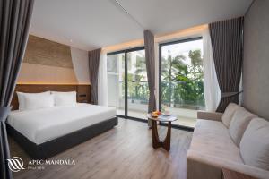 ein Hotelzimmer mit einem Bett und einem Sofa in der Unterkunft Mandala Hotel & Spa Phú Yên in Tuy Hoa