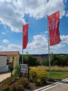 two red flags on poles in a garden at Gästehaus Staudenschloss in Mickhausen