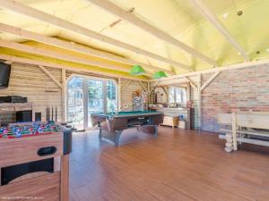 a living room with a pool table and a table at Domki Pod Lasem in Mrzeżyno