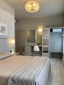 1 dormitorio con 1 cama grande y lámpara de araña en Hotel La Pace, en San Mauro Torinese