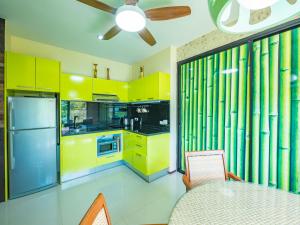a kitchen with yellow cabinets and a ceiling fan at Condo AVANTA Deluxe A301 in Mae Nam