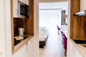 ハーネンクレー・ボックスヴィーゼにあるHaus am See Luxury HS 225 Bのキッチン、ベッドルームが備わる小さな客室です。