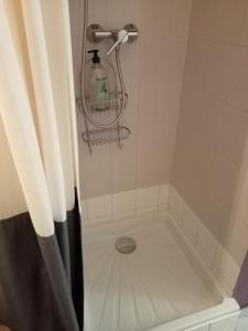 uma banheira com um chuveiro e uma garrafa. em Zoulysse III Annecy em Annecy