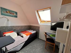 a small room with a bed and a desk at Pension "Tor zum Rennsteig" in Hörschel