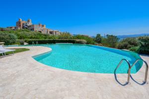 a swimming pool with blue water in a villa at Villetta Azzurro - SHERDENIA Luxury Apartments in Marinella