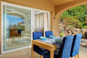 una sala da pranzo con tavolo e sedie blu di Villetta Azzurro - SHERDENIA Luxury Apartments a Marinella