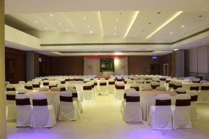 a banquet hall with white tables and white chairs at Hotel Niya Regency in Trichūr
