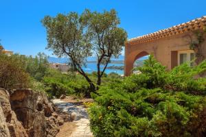 una casa su una collina con alberi e un giardino di Villetta Azzurro - SHERDENIA Luxury Apartments a Marinella