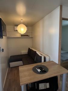 een kleine woonkamer met een tafel en een bank bij ZEN MURTER Mobil home in Betina