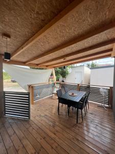ZEN MURTER Mobil home في بيتينا: فناء على طاولة وكراسي على سطح خشبي