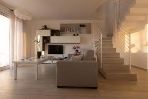 a living room with a staircase and a couch and a table at Villa Cristina - Relax - Piscina e Vista Mare in Castellammare del Golfo