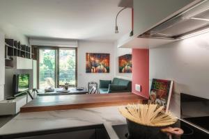 a kitchen with a living room with a couch at JOIVY Luxury flat & Lake Como view in Argegno