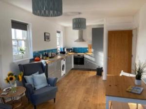 a living room with a table and a kitchen at Flat 6 George Street in Teignmouth