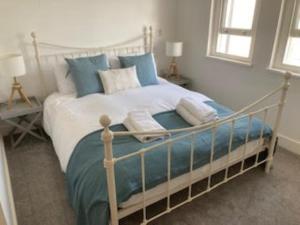 a bedroom with a large bed with blue and white pillows at Flat 6 George Street in Teignmouth