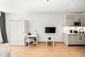 een witte kamer met een bureau en een keuken bij Boutique Space VIE #4o3 in Wenen