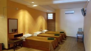 a room with three beds and a mirror at Straits Settlement Inn in Malacca