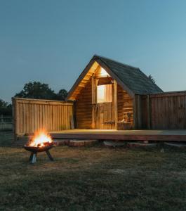 a log cabin with a fire in front of it at Glamping at the Retreat Wiltshire is rural bliss in Chippenham