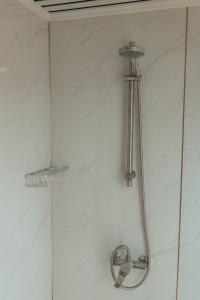 a shower with a shower head on a wall at Glamping at the Retreat Wiltshire is rural bliss in Chippenham