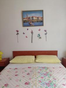 1 dormitorio con 1 cama con flores y mariposas en la pared en Apartment Nenadic, en Hrahorić