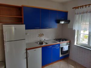 cocina con armarios azules y nevera blanca en Apartment Nenadic, en Hrahorić
