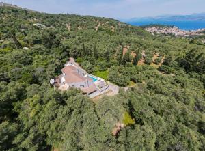 an aerial view of a house on a hill with trees at Villa Leveque - Kassiopi Hillside pool villa in Kassiopi