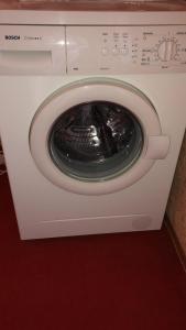 a white washing machine with its door open at KULDIGAS 38 APARTMENTS in Liepāja