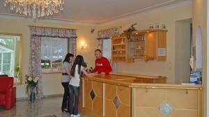 a man and a woman standing at a kitchen counter at Gästehaus Am Ludwigsberg in Bad Koetzting