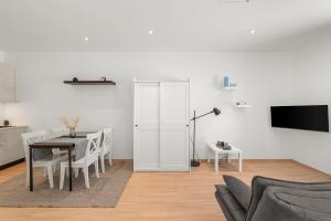a white living room with a table and a tv at VibeStudio B2 - Central Vienna 1090 - 50m2 - Self Check-In - AC in Vienna
