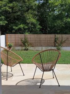 dwie ławki siedzące obok siebie na patio w obiekcie Maison Caiada w mieście Urrugne