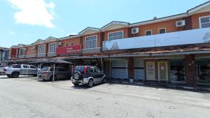 Straits Settlement Inn في ميلاكا: سيارة صغيرة متوقفة في موقف للسيارات أمام المباني