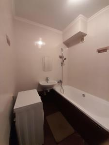 a white bathroom with a tub and a sink at Lux na Osipenko in Uzhhorod