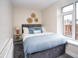 a bedroom with a large bed and a window at The Views Townhouse in Newcastle