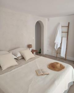 a white bed with a hat and two books on it at Maison Caiada in Urrugne