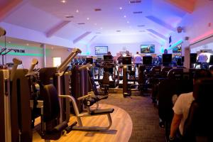 a gym with a bunch of cardio equipment in it at Whittlebury Hall and Spa in Whittlebury